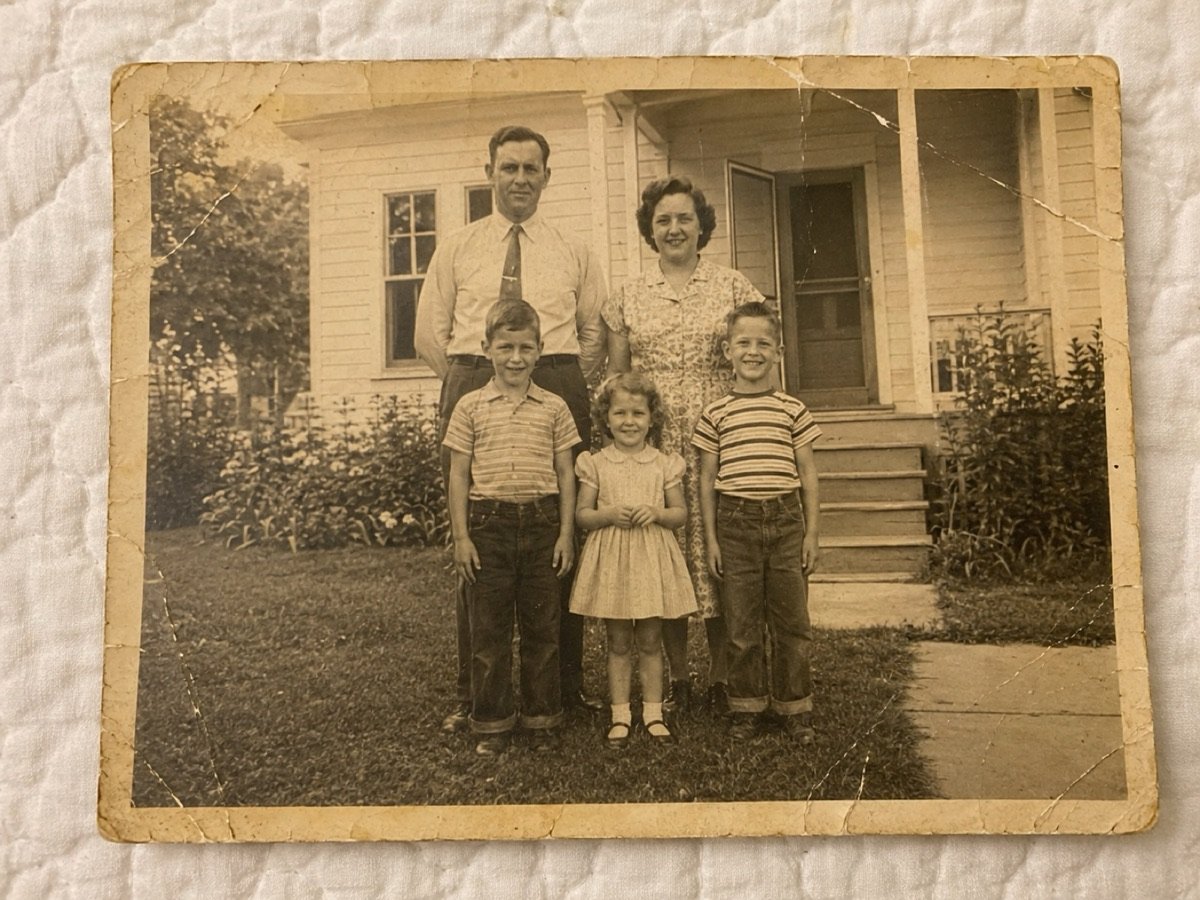 Foto original: familia reunida frente a la casa en los años 50