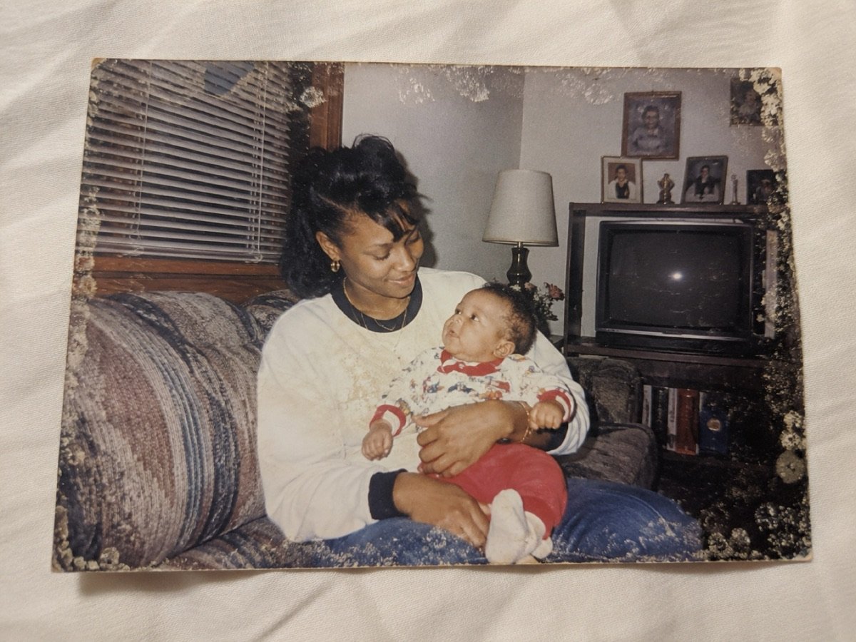 Foto original: madre con su bebé en brazos, en la sala